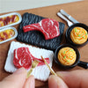 A miniature dollhouse set featuring beef steak and pasta food items on a wooden board.