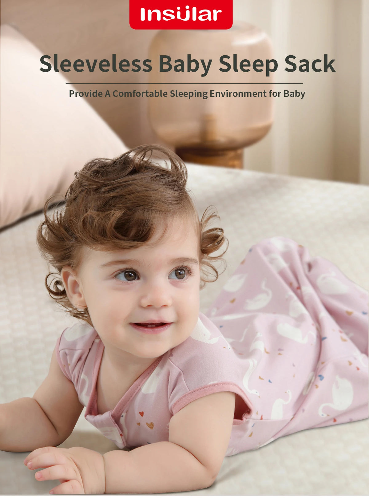 A smiling baby wearing a pink sleeveless sleep sack lying on a light-colored surface.