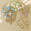 A collection of soft silicone butterfly teethers in various pastel colors, including blue, green, pink, and white.