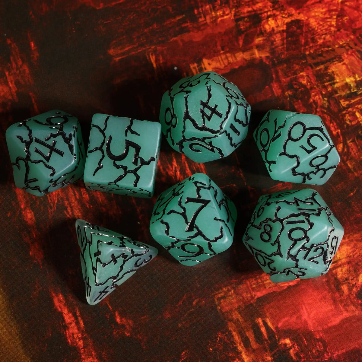 A set of seven frosted crack resin polyhedral dice in a teal or seafoam green color resting on a dark, textured surface.