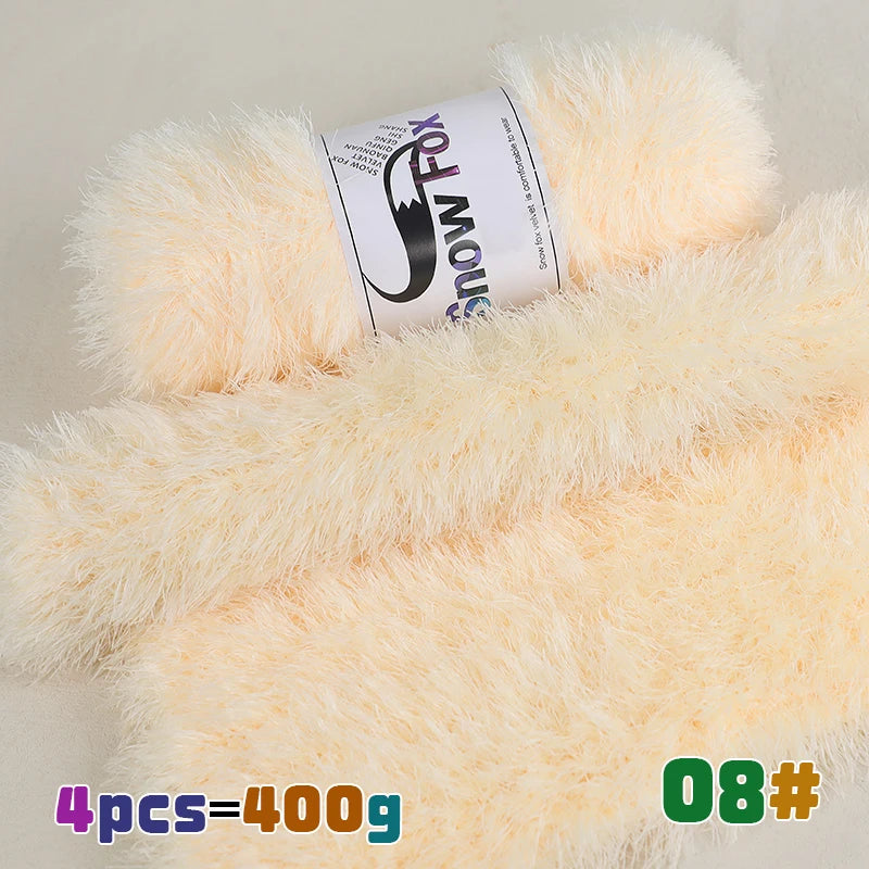 A bundle of fluffy, pale yellow faux fur yarn is displayed next to a label showing the brand Snow Fox.