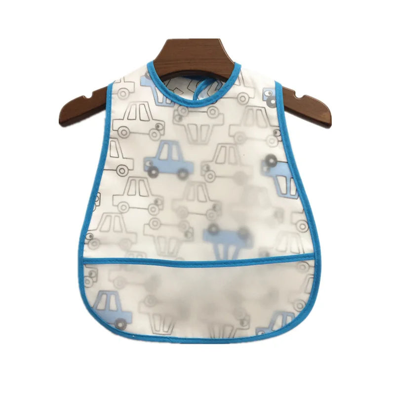 A white waterproof baby bib with a cartoon vehicle pattern hanging on a wooden hanger.