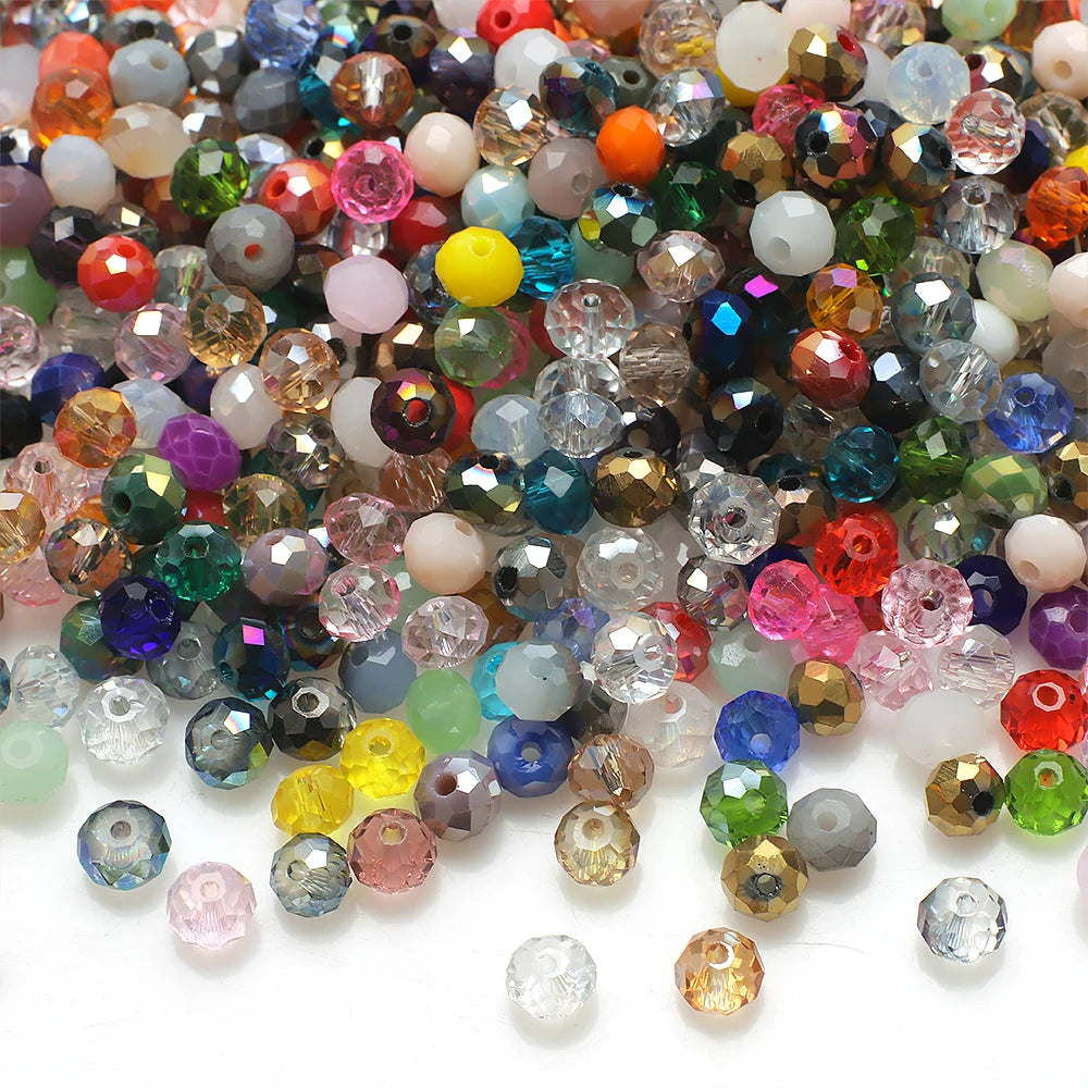A close-up view of various faceted crystal rondelle glass beads in a colorful assortment for jewelry making