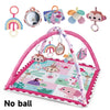 A pink baby play mat with a fitness frame and various hanging toys for baby development.