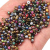 A handful of golden gradient glass beads in various colors and shades for DIY jewelry making