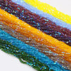 A close-up of multicolored crystal triangle beads in a rainbow gradient arrangement.
