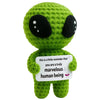 Handmade crochet alien figure in bright green with large black eyes holding a white tag that reads you are a truly marvelous 