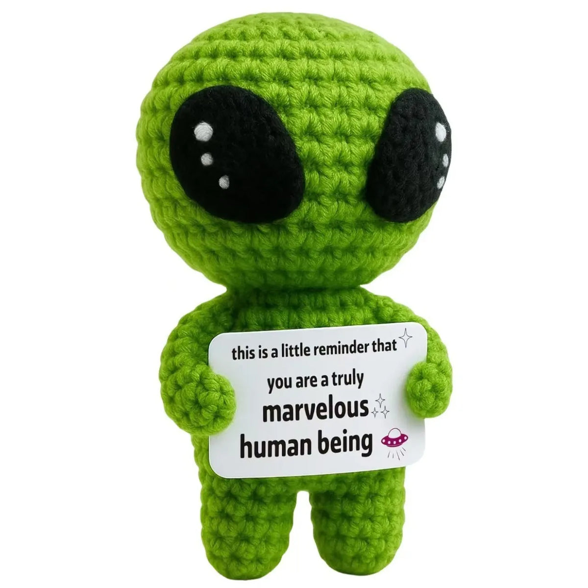 Handmade crochet alien figure in bright green with large black eyes holding a white tag that reads you are a truly marvelous 