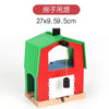 A red wooden house model with a green roof and an arched window, featuring a black light fixture.