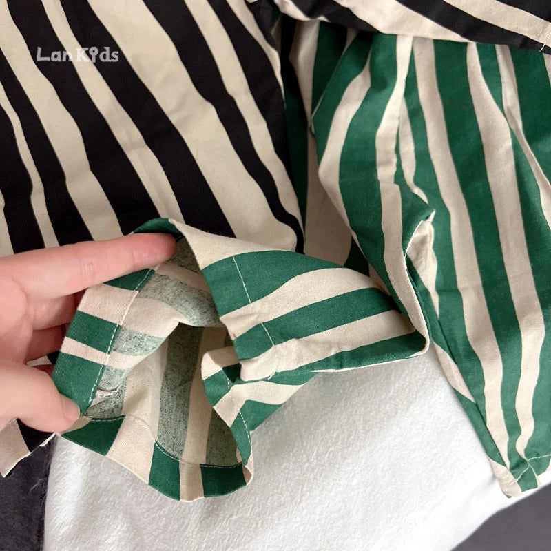 Close-up of striped cotton harem pants for kids showing the fabric texture and green and beige stripes.