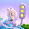 A fluffy purple Labubu plush doll with white teeth and a flower, standing next to a purple light bulb.