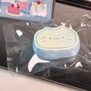 A light blue cat-shaped squishy toy is sealed in clear plastic packaging.