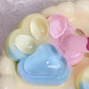 A close-up of a pastel colored squishy toy shaped like a cat paw, featuring shades of pink, blue, and cream.