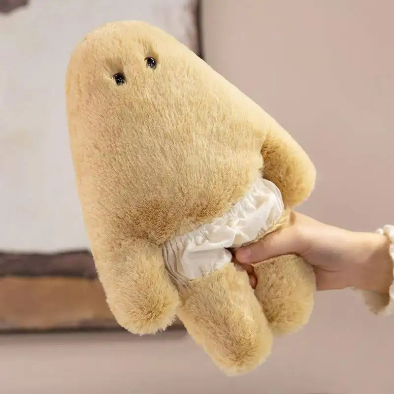 A light beige monster plush doll with a soft texture is being held by a person.