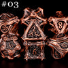 A set of seven polyhedral metal dice in a bronze or copper finish, arranged against a black background.
