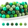 A pile of round silicone beads in various shades of green and teal for jewelry making