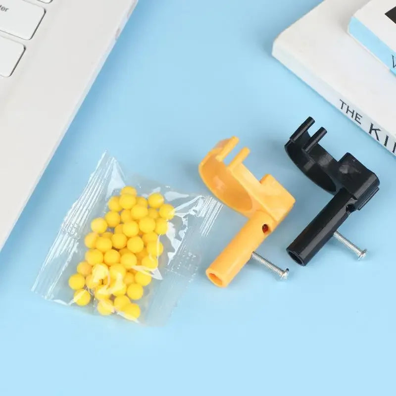 A yellow finger ring launcher fidget toy with black components and screws is shown on a light blue surface.