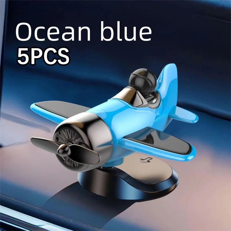 Five ocean blue solar powered rotating airplane dashboard ornaments displayed on a dark surface.