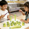 Two children play with a stretchy fishing toy featuring green and yellow fish on a white surface.