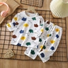 White long sleeve cotton pajama set for kids featuring a pattern of colorful fruit and animal shapes