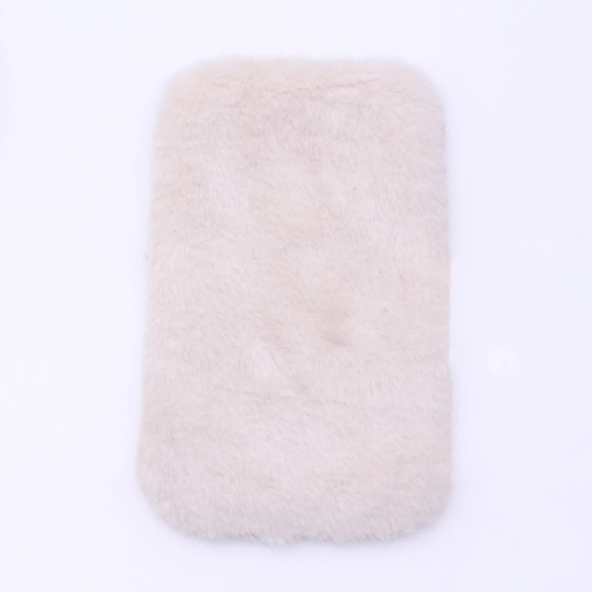A rectangular, fluffy, light pink faux fur mat used for dollhouse decor.