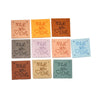 A collection of twenty embossed leather labels in various shades of brown and orange, each stamped with the words Made with L