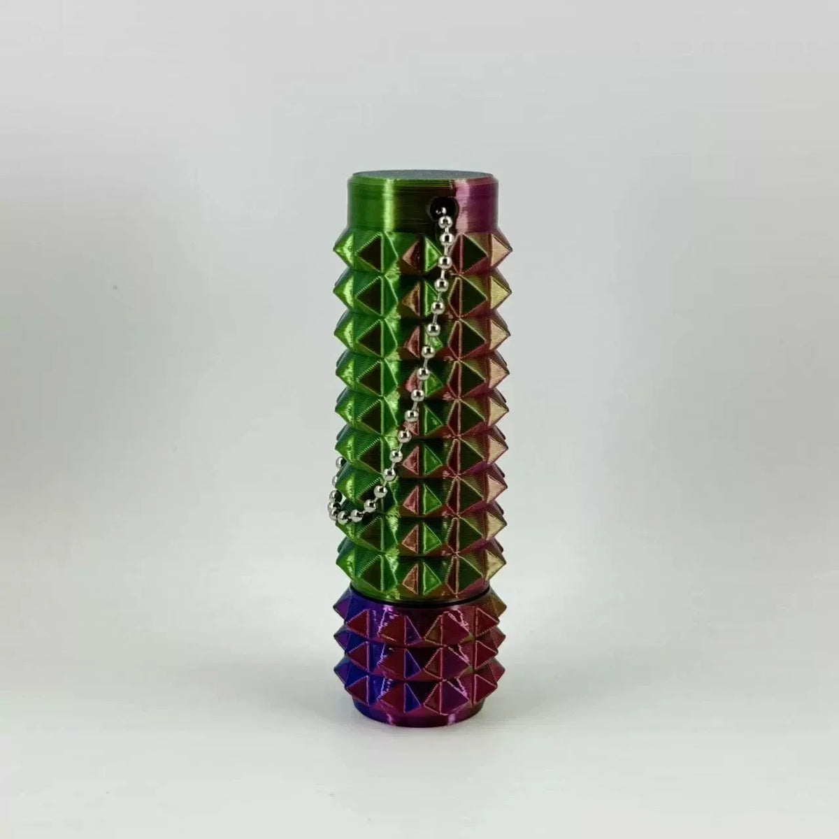 A stack of green and purple 3D printed spike roller fidget toys.