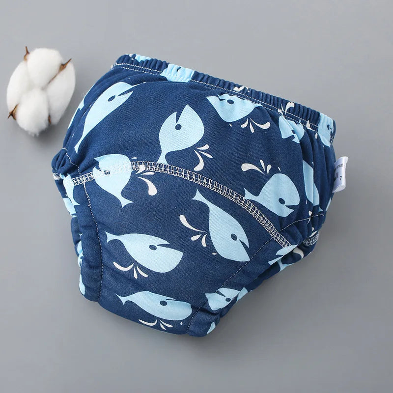 Pantalones de entrenamiento lavables azules marinos para bebés con estampado de ballena blanca y azul claro.