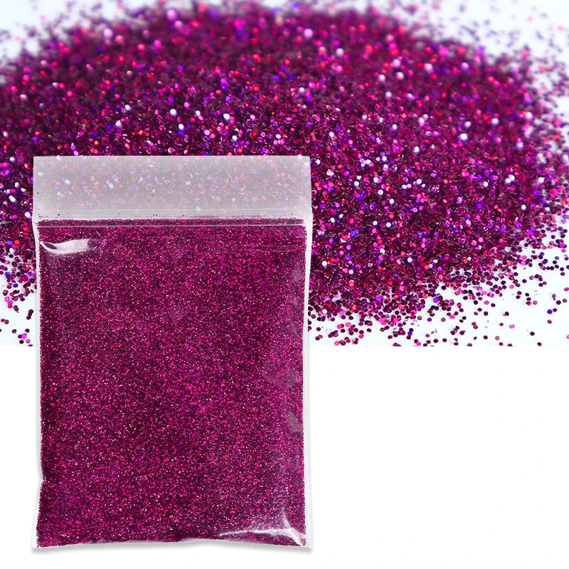 A small plastic bag filled with vibrant magenta holographic glitter powder scattered across the surface.