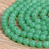 A strand of small, round, translucent green Aventurine gemstone beads for jewelry making