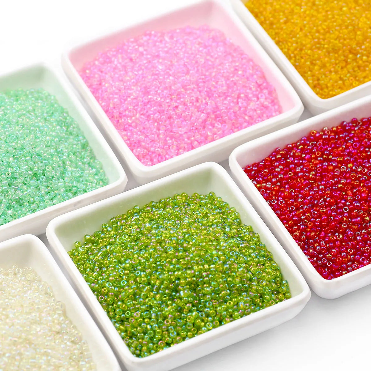 A collection of brightly colored glossy glass seed beads in various shades including pink, yellow, green, and red.