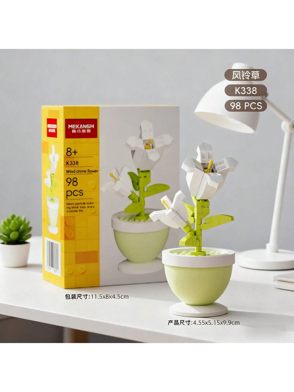 A set of three white flower vases with green stems and leaves displayed on a white table.