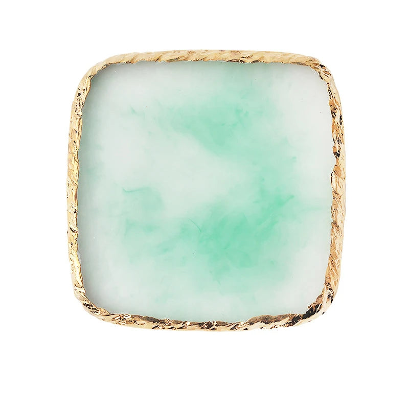 A square resin nail art palette with a pale mint green color and a gold textured trim.