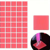 A grid of 80 pink silicone putty pieces for diamond painting or rhinestone application, with a single piece shown on a red ba