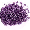 A pile of small, purple metallic glass beads for jewelry making.