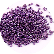A pile of small, purple metallic glass beads for jewelry making.