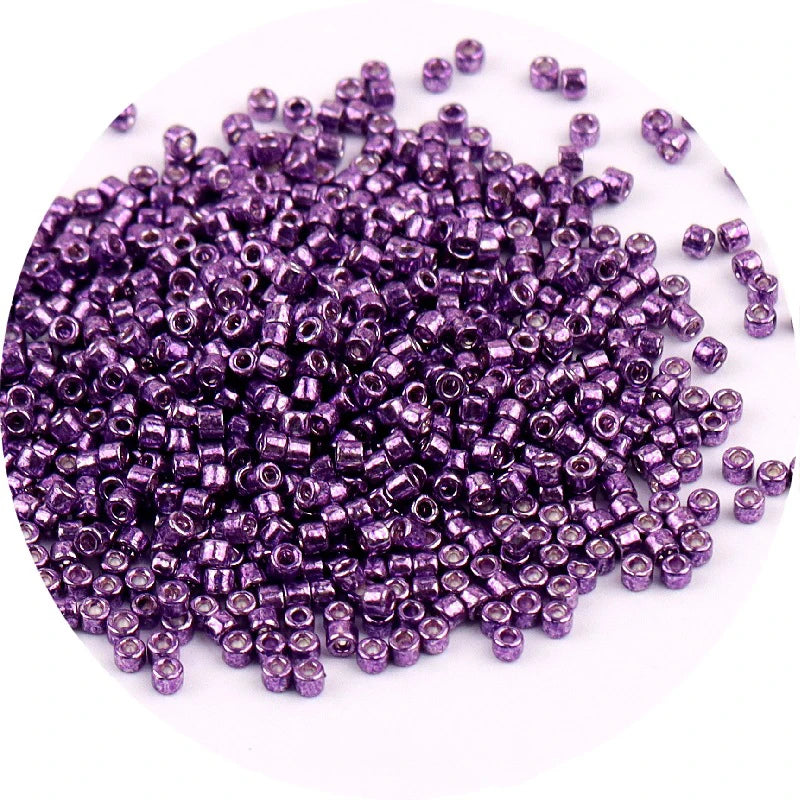 A pile of small, purple metallic glass beads for jewelry making.