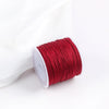 A roll of red macrame cord for jewelry making and crafts.