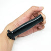 A hand holds a black retractable trick dagger prop knife.