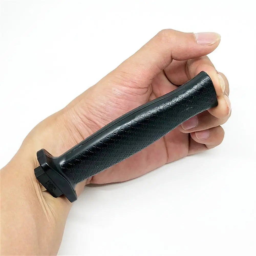 A hand holds a black retractable trick dagger prop knife.