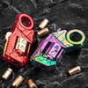 A red and purple metal gun-shaped fidget slider with brass components on a dark surface.