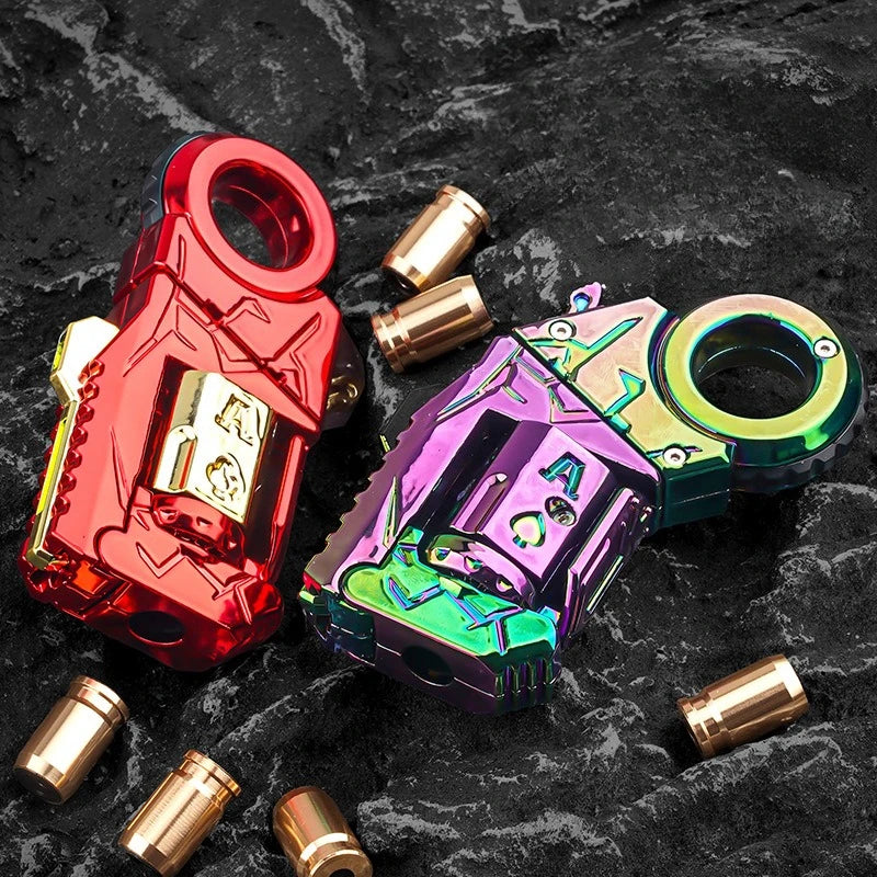 A red and purple metal gun-shaped fidget slider with brass components on a dark surface.
