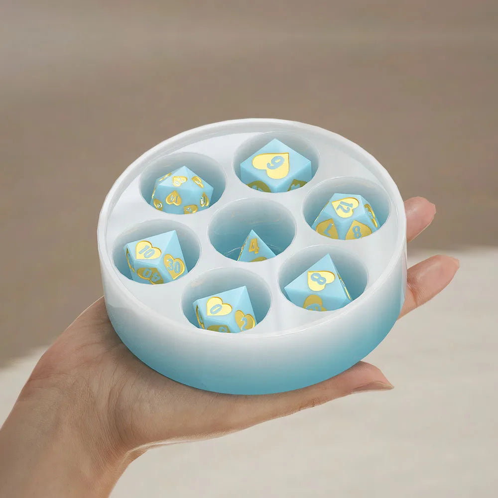 A hand holds a silicone resin mold set with six hexagonal compartments, containing custom dice.