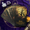 A deck of oracle cards with a dark, mystical design resting on a purple velvet cloth.