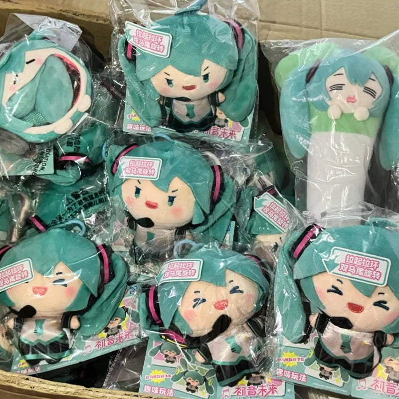 A collection of green and pink Hatsune Miku plush keychains packaged in clear plastic bags.