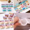 A collection of colorful silicone soap and candle molds in various shapes and colors arranged on a white surface.