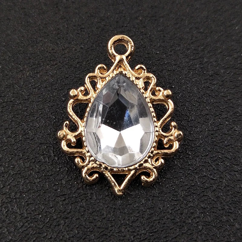 Gold plated water droplet charm featuring a clear crystal rhinestone set in an ornate flower design.