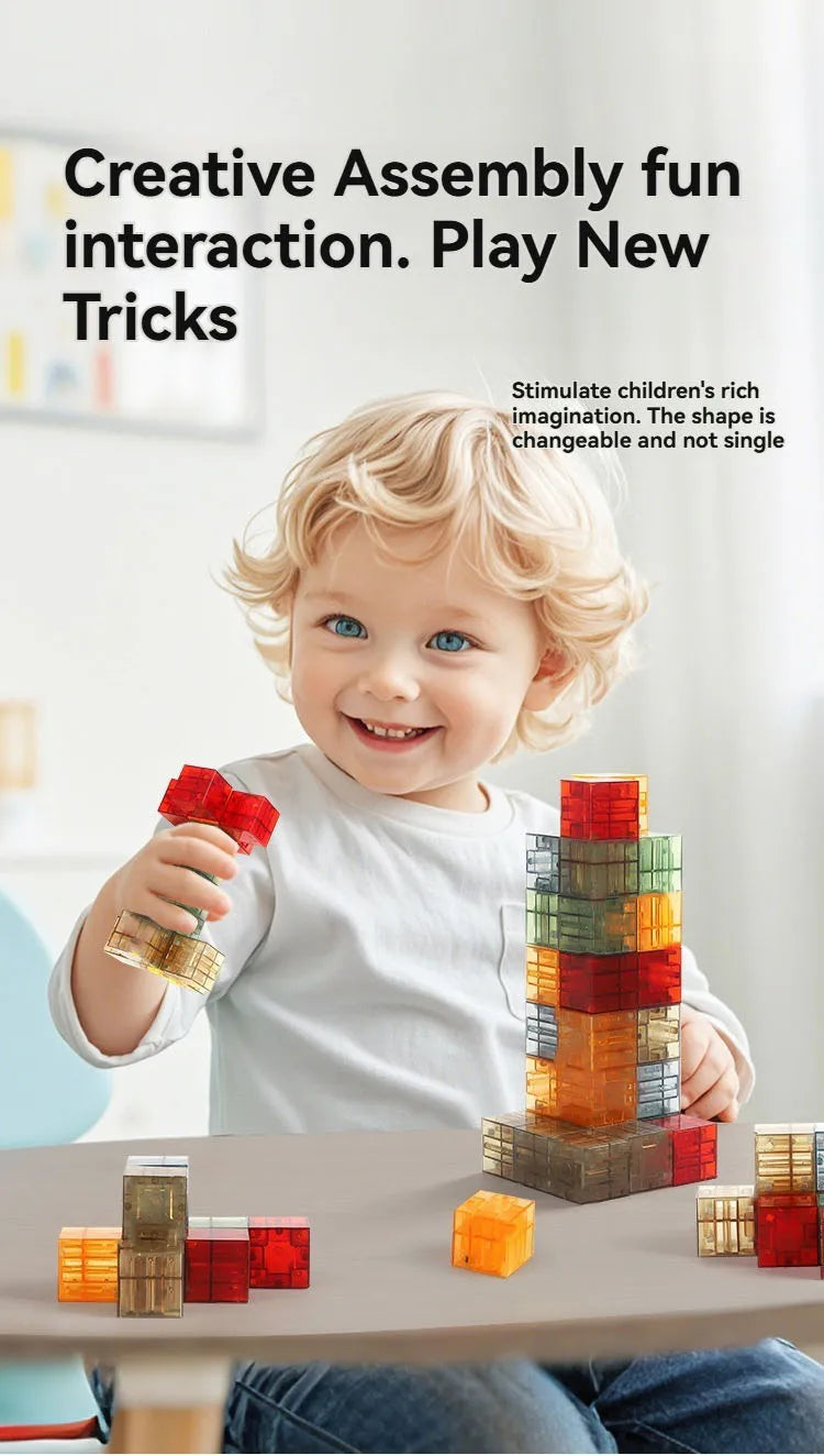 A smiling toddler is building a tower with colorful magnetic blocks on a table.