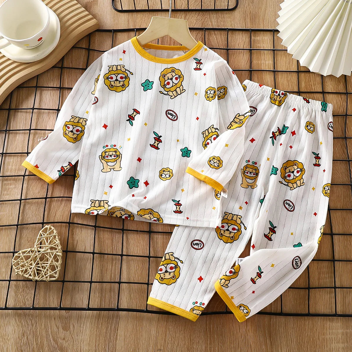 White long sleeve cotton pajama set for kids featuring lion and star patterns