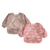 A full-sleeve waterproof baby bib in pink with a white cartoon rainbow design.